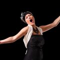 A picture of a young beautiful opera singer performing over black background